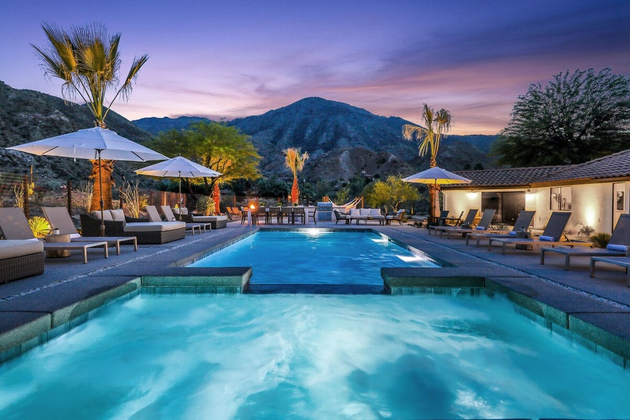 Pool lit at night time overlooking the mountains