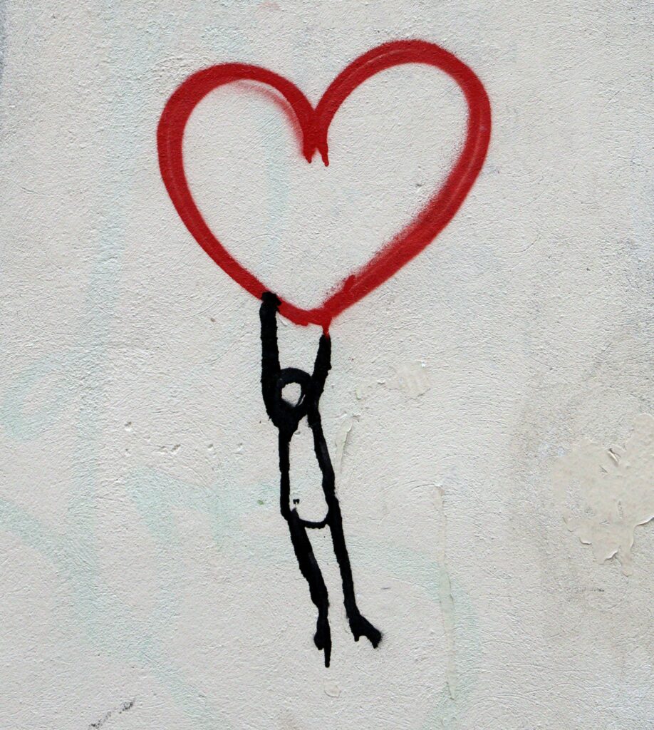 Graffiti of a stick man holding onto a heart