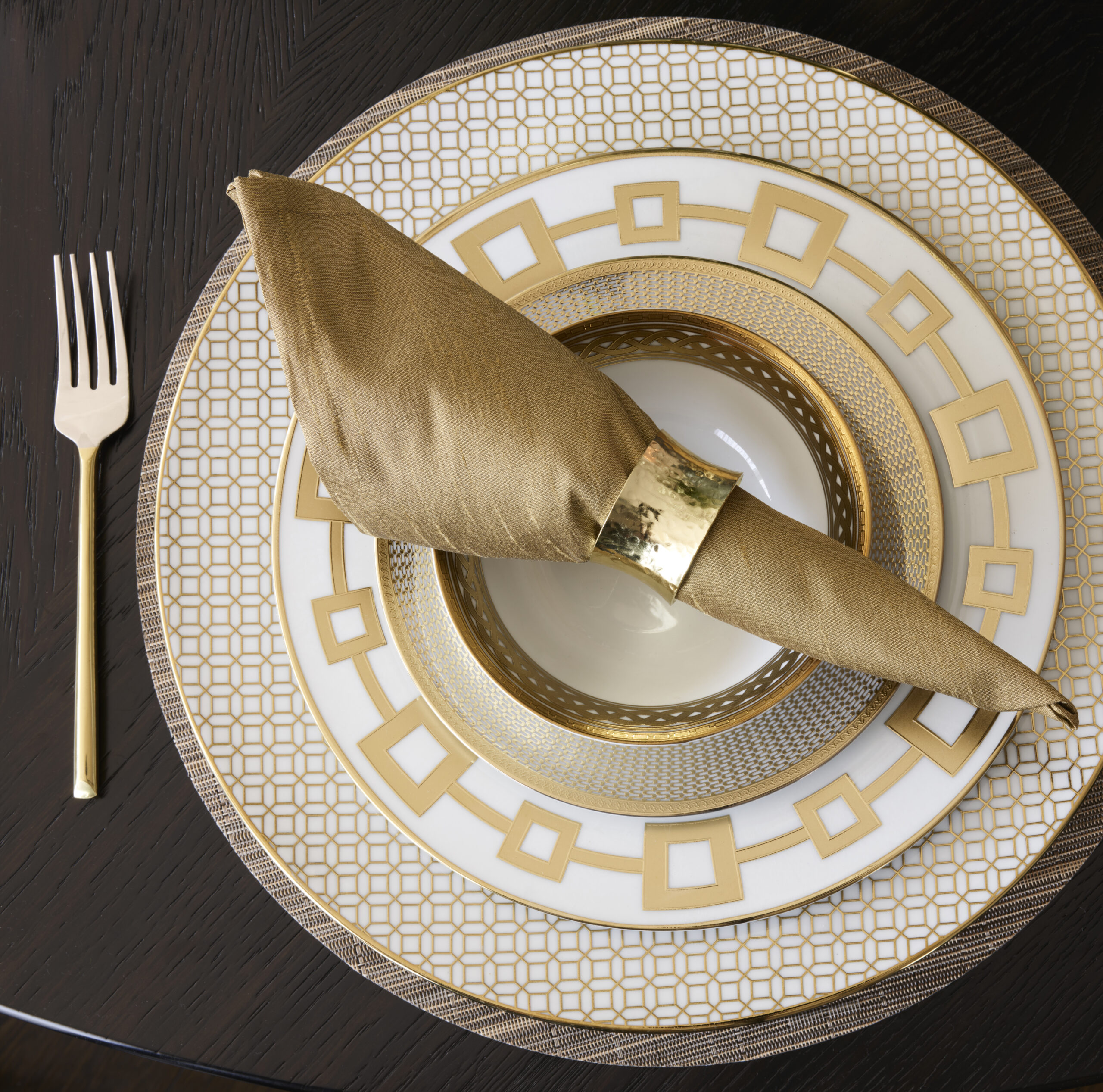 Charger plate with gold napkin in a gold napkin ring